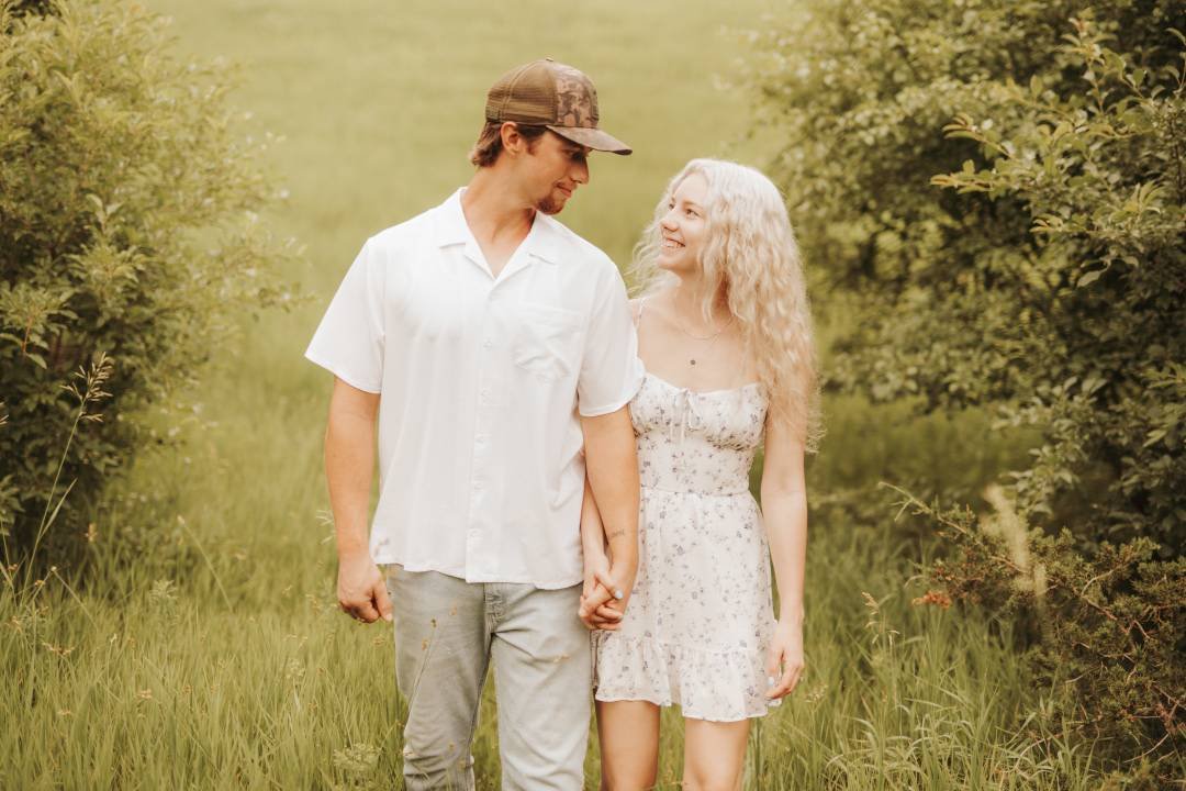 Engagement couple walking in fields