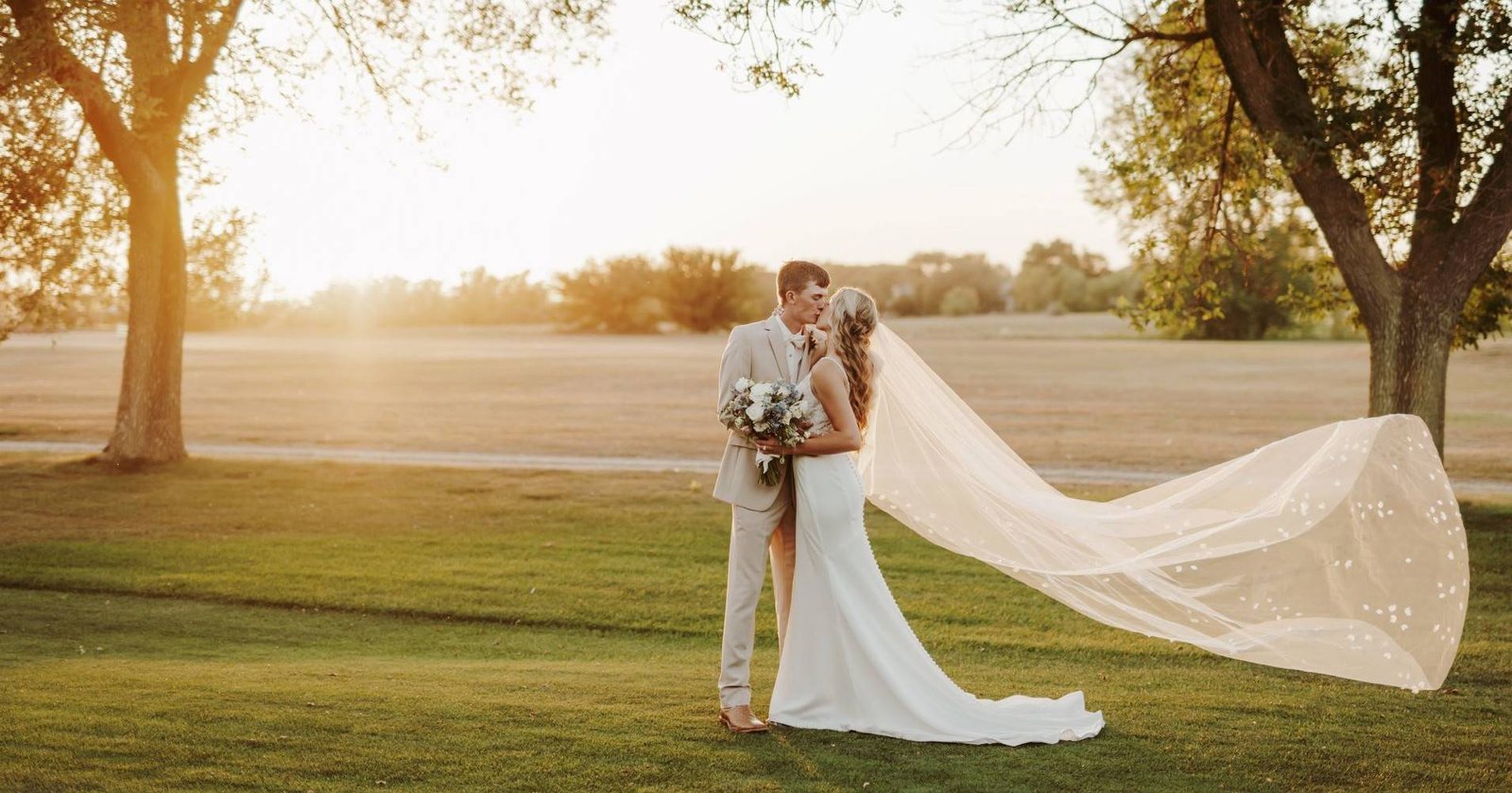 Wedding couple looking at each other with veil in wind