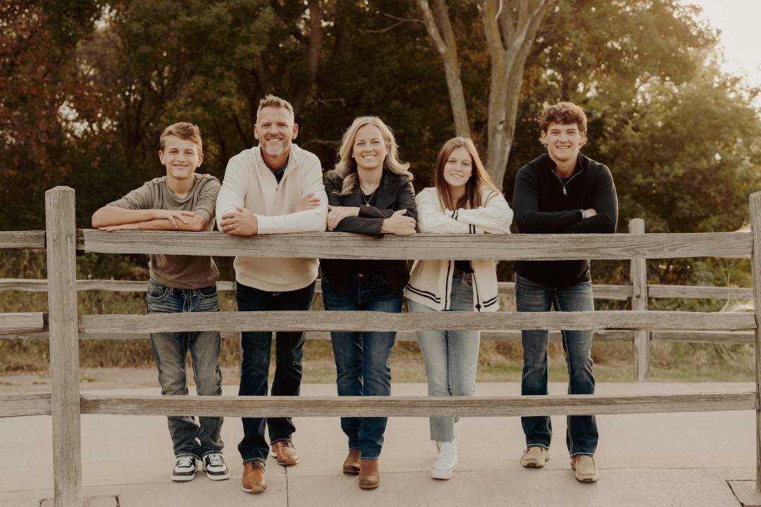 Family leaning on a fence